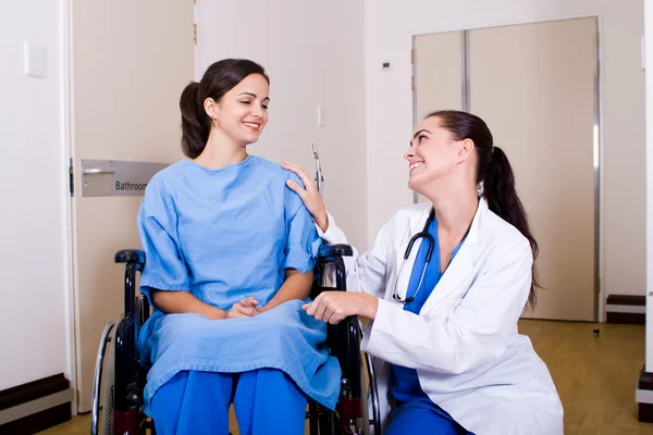 Fürsorgliche Krankenschwester im Gespräch mit einem Patienten, der im Rollstuhl sitzt — Stockfoto