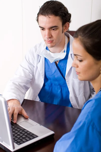 Doctor y enfermera usando computadora portátil en la oficina — Foto de Stock