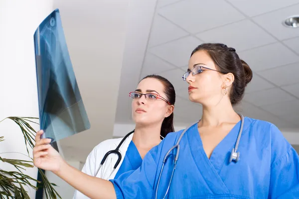 Dva lékaři při pohledu na pacienta x ray — Stock fotografie