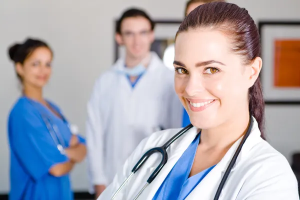 Pretty young female doctor and colleagues Stock Picture