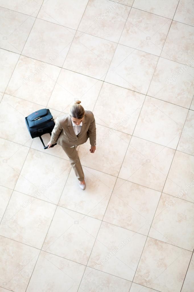 Overhead view of young woman walking at airport