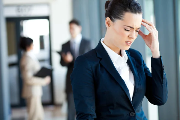 Jeune femme d'affaires ayant mal à la tête au travail — Photo