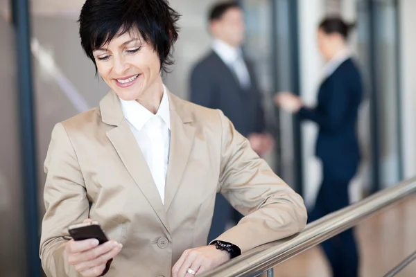 Geschäftsfrau mittleren Alters nutzt Smartphone — Stockfoto