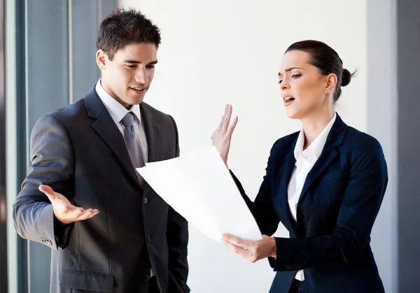 Två unga kollegor argumenterar över pappersarbete i office — Stockfoto