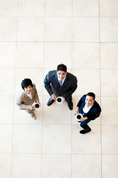 Bovenaanzicht van collega's hebben koffiepauze op het werk — Stockfoto