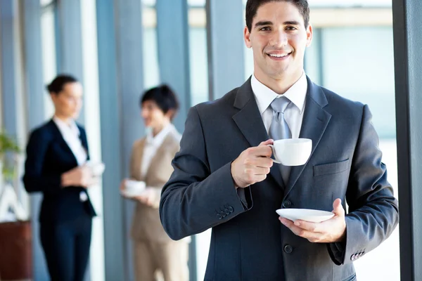 Ung affärsman med kaffepaus i office Stockbild