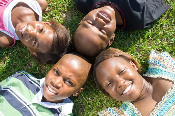 Gruppo di bambini afro-americani sdraiati sull'erba — Foto Stock