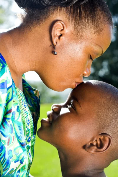 Amando afro-americana mãe beijando seu filho na testa — Fotografia de Stock