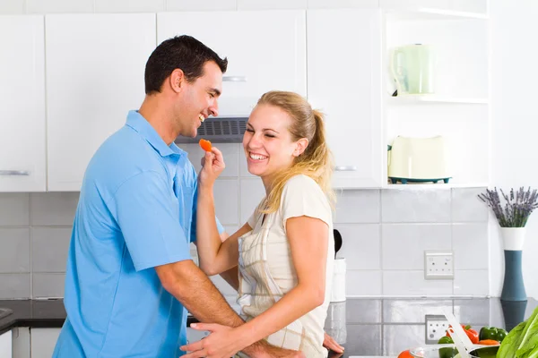 Young woman and husband cooking in kitchen — Stock Photo, Image