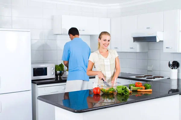 Young woman and husband cooking in kitchen — Stock Photo, Image