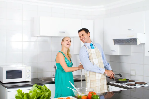 Feliz pareja joven cocinando en la cocina —  Fotos de Stock