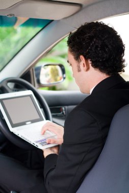 bir arabanın içinde çalışan iş adamı
