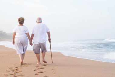 Senior couple hand in hand walking clipart
