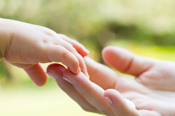 Caring mother and baby's hands