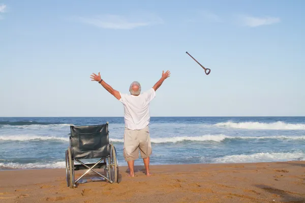 Старший мужчина встает с инвалидного кресла — стоковое фото