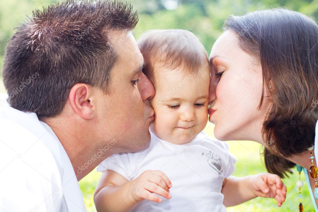 Parents kissing baby girl