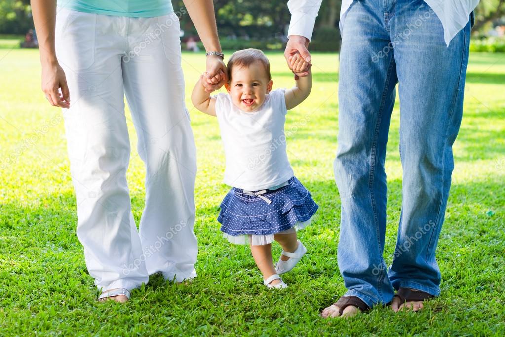 Cute baby girl walking with parents — Stock Photo © michaeljung