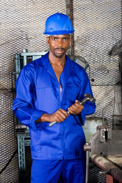 Jeune usine africaine travaillant en atelier avec marteau — Photo