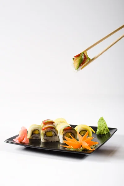 Baguettes ramasser des rouleaux de sushi — Photo