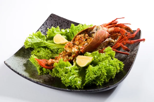 Cooked large lobster in a bowl with lettuce and lemon — Stock Photo, Image