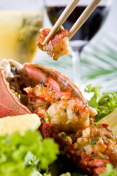 Eating cooked lobster with chopsticks — Stock Photo, Image