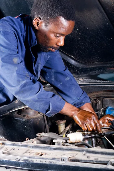 Afrikanischer Amerikaner repariert Auto in Garage — Stockfoto