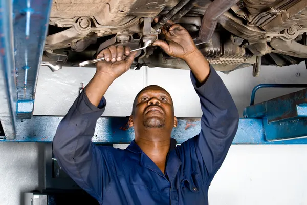 Mecánico afroamericano trabajando en un vehículo averiado — Foto de Stock