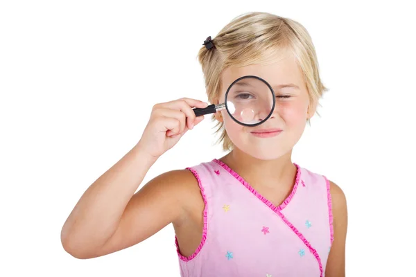 Hermosa niña mirando a través de una lupa — Foto de Stock