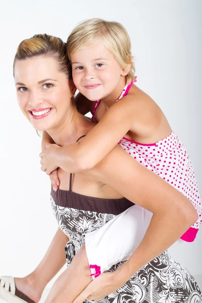 Bonne petite fille piggyback avec sa mère , — Photo