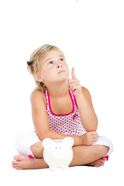 Little girl with piggybank and pointing — Stock Photo, Image