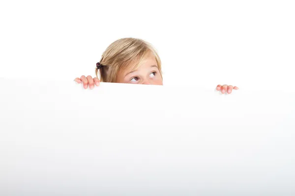 Cute little girl behind white board with funny facial expression — Stock Photo, Image