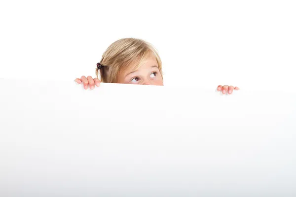 Carino bambina dietro bianco bordo con divertente faccia espressione — Foto Stock