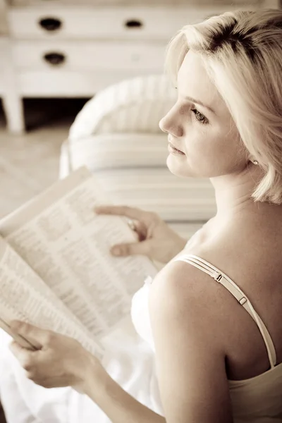 Elegante junge Frau liest Buch zu Hause — Stockfoto