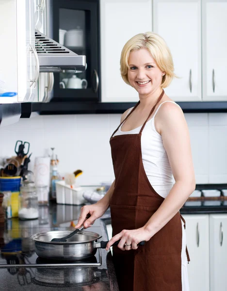 Happy woman cooking in kitchen — Stock Photo, Image