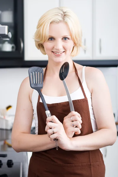 Szczęśliwa młoda kobieta z naczynia w kuchni — Zdjęcie stockowe