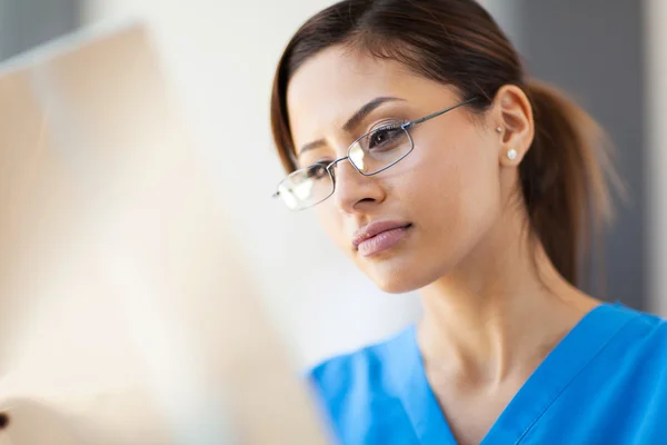 Jeune jolie travailleuse médicale regardant un film radiographique — Photo