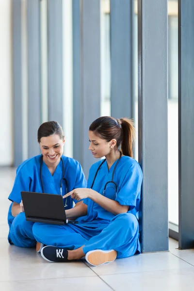 Dos trabajadoras médicas usando computadora portátil durante el descanso — Foto de Stock