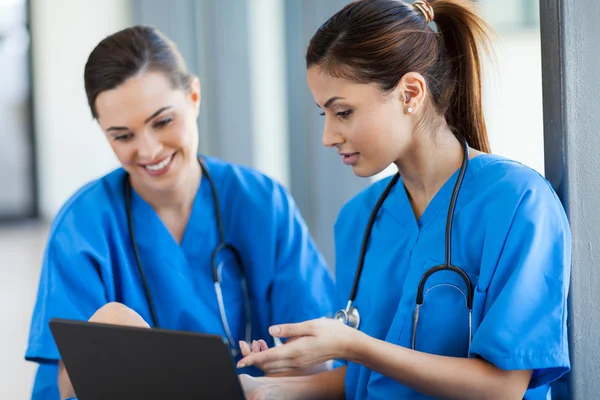 Two beautiful female healthcare workers using laptop — Stock Photo, Image