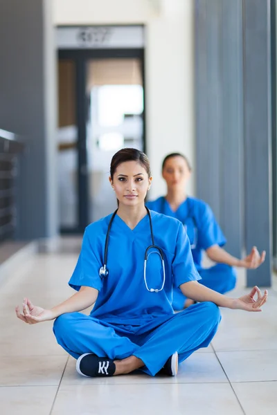 Dos hermosas enfermeras haciendo meditación durante el descanso en el hospital —  Fotos de Stock