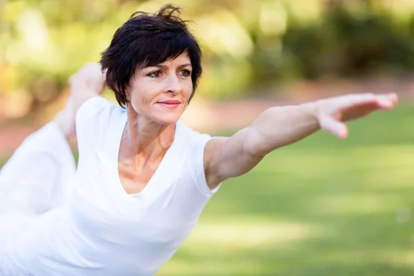 Healthy middle aged woman stretching outdoors