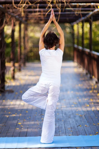 Visão traseira da mulher de meia idade fazendo pose de ioga — Fotografia de Stock