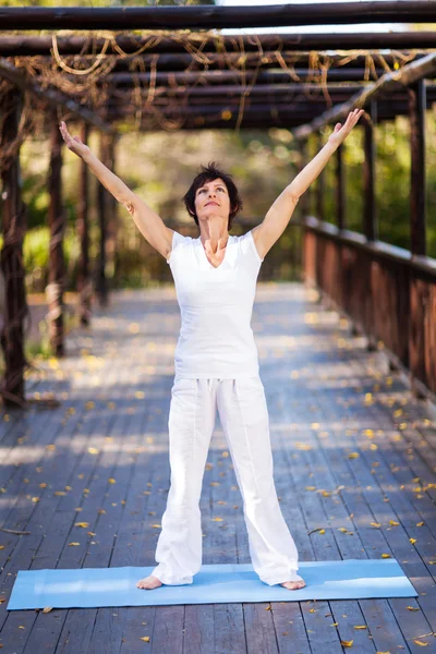 Saludables brazos de mujer de mediana edad alcanzan — Foto de Stock