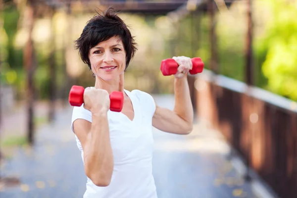 Actieve midden leeftijd vrouw training met halters — Stockfoto