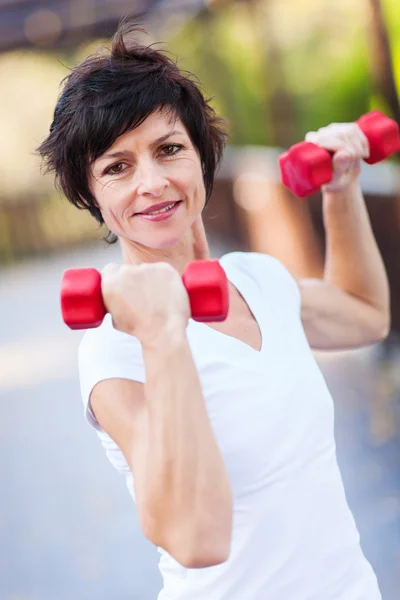 Orta yaşlı kadın egzersiz dumbbells ile — Stok fotoğraf