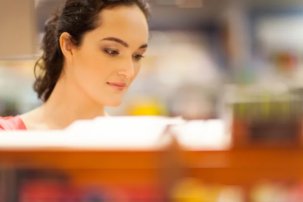 Junge Frau kauft ein und wählt Produkte im Geschäft aus — Stockfoto