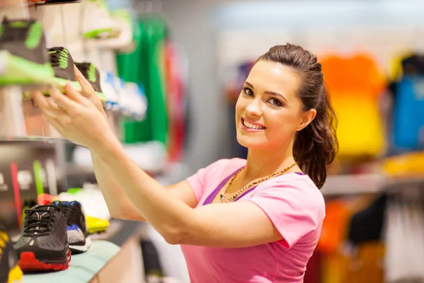 Happy young woman shopping for sports footwear — Stock Photo, Image