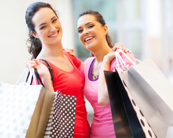 Filles heureuses avec sacs à provisions dans le centre commercial — Photo