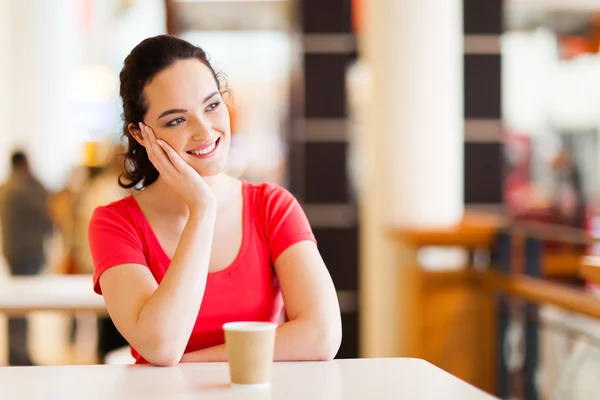Šťastná mladá žena sedí v kavárně — Stock fotografie