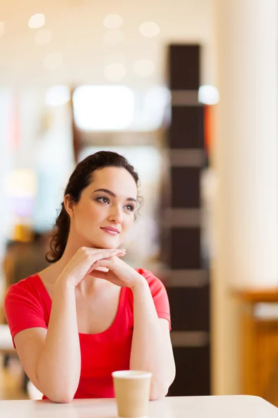 Glückliche junge Frau sitzt im Café — Stockfoto