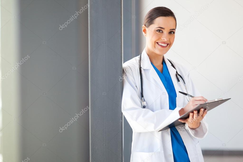 Female medical worker writing report in office